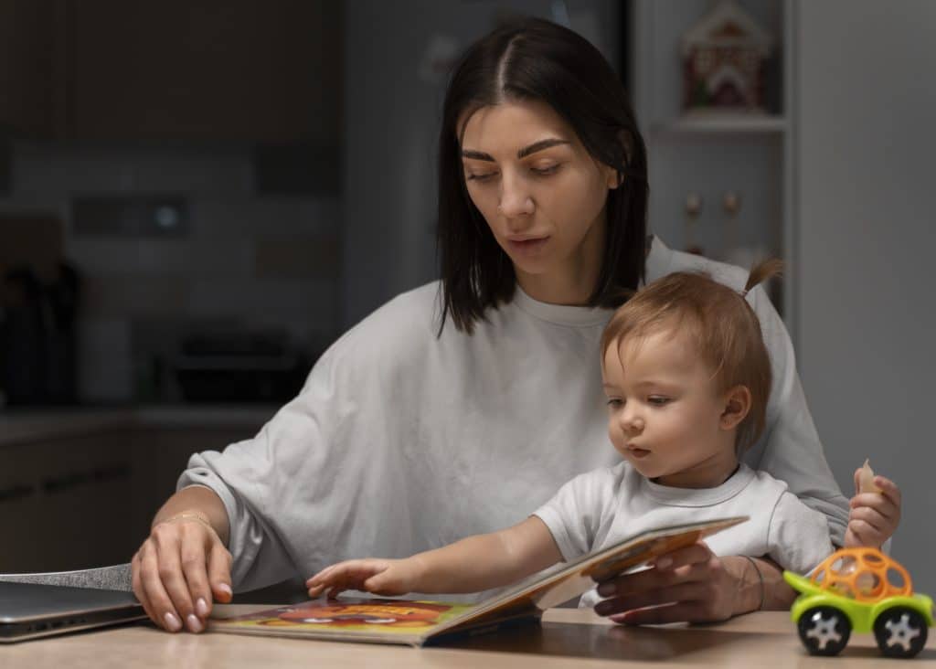 medium shot mother baby with book
