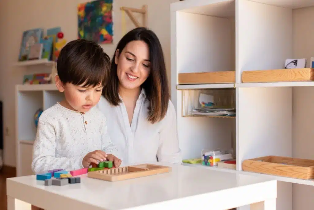 Nanny teaching young girl using Montessori-inspired learning tools