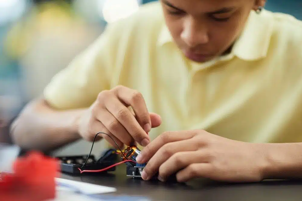 een working on a robotic arm at Tech Revolution Camp held at Rice University in Houston.