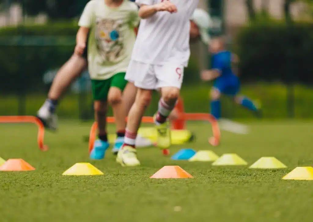 Children running in a field playing organized outdoor games at YMCA Summer Camp Houston.