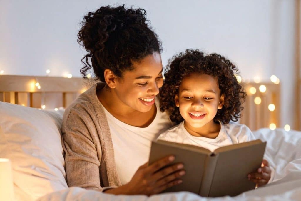 Nanny reading a bedtime story to a child before sleep in a softly lit room.