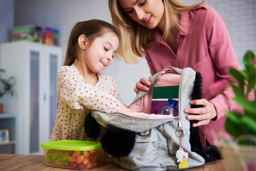Nanny helping parents organize bags and schedules for weekend activities.