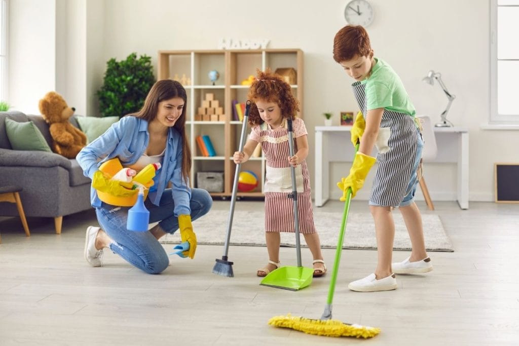 Parent and nanny modeling kindness by helping children work together on a projec