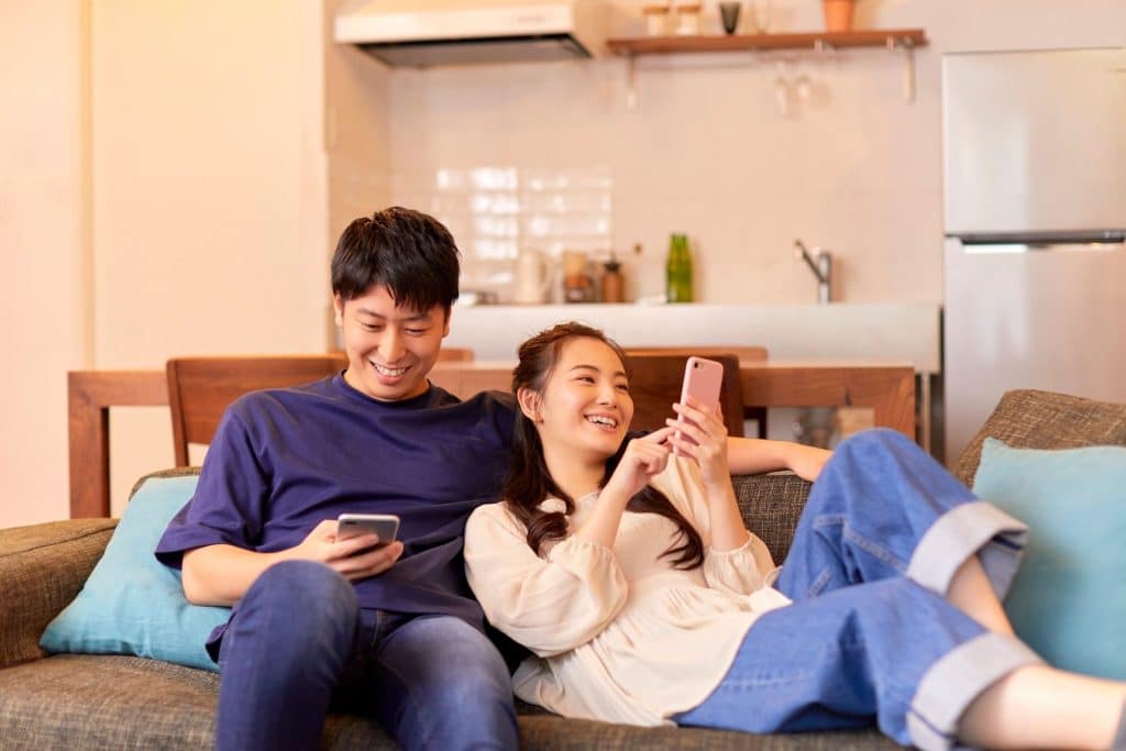 Happy Houston parents relaxing while their carefully vetted nanny plays with their child.