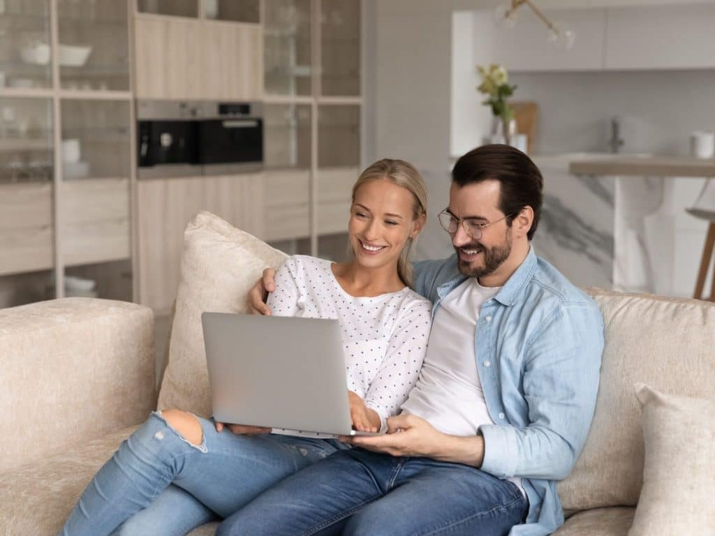 Parent conducting a nanny background check alongside reviewing references on a laptop.