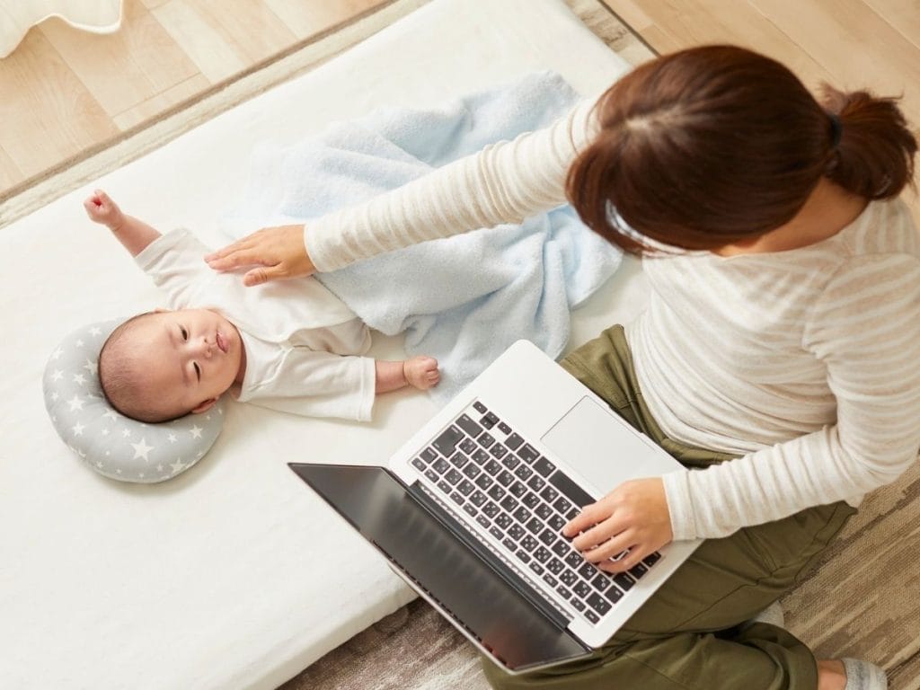 Newborn care specialist updating a baby’s feeding and sleep log while parents observe.