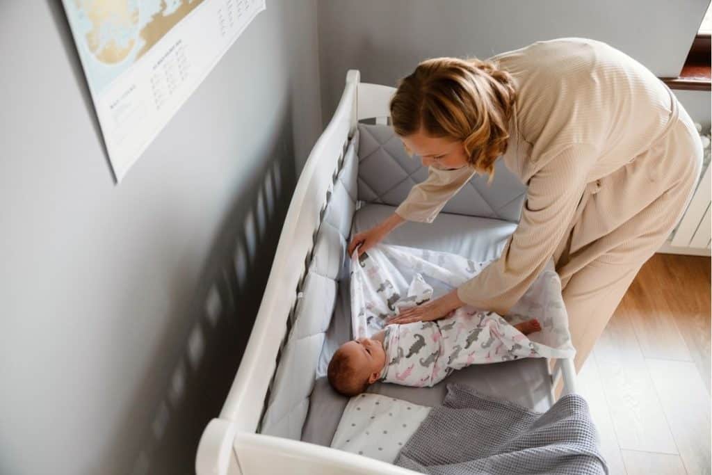 Newborn care specialist teaching parents how to feed and swaddle their baby at home.