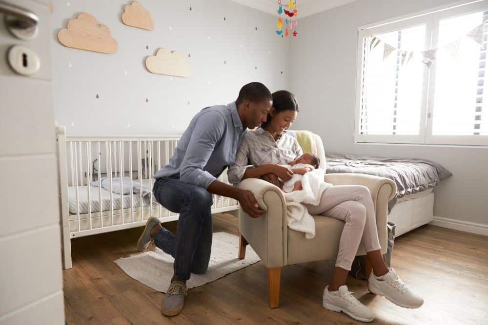 Newborn care specialist teaching parents safe sleep techniques for their infant