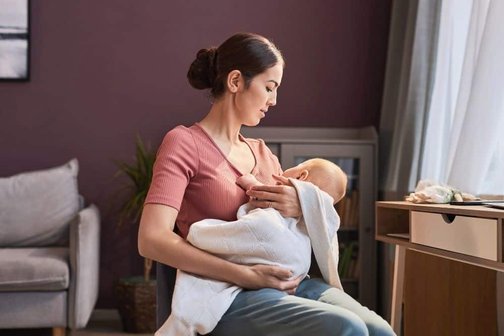 Overnight nanny holding a baby and rocking them to sleep during nighttime care.