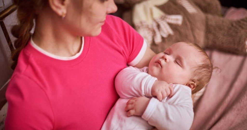Night nanny in Houston gently rocking newborn during late-night shift