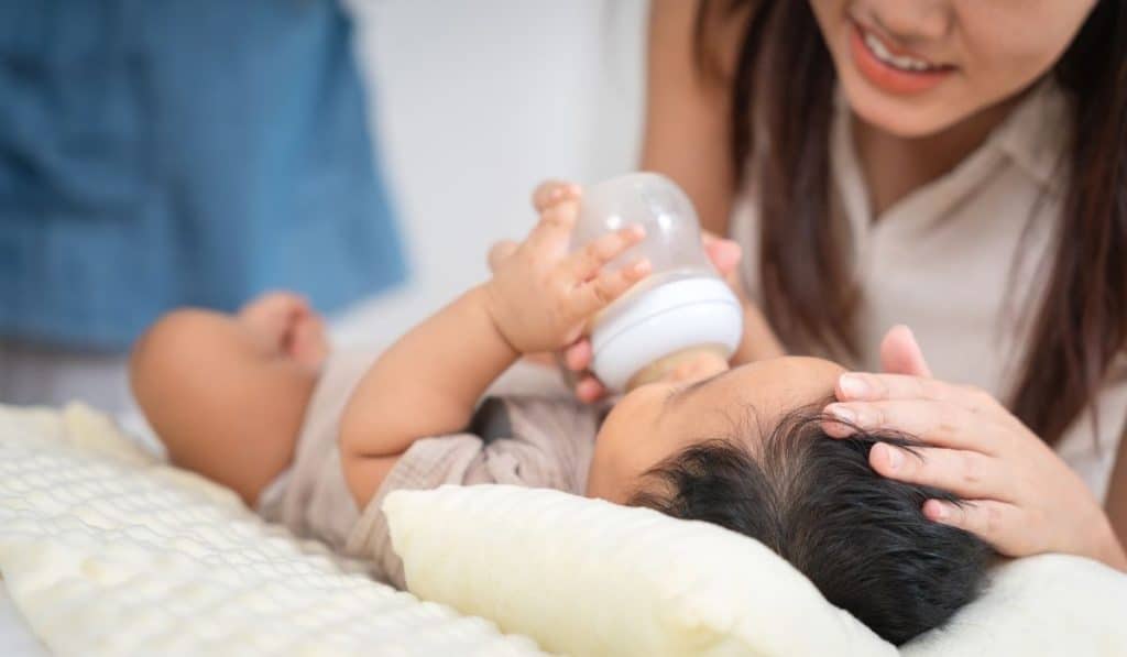 Certified newborn care specialist tracking a newborn’s feeds and sleep schedule in a Houston home.