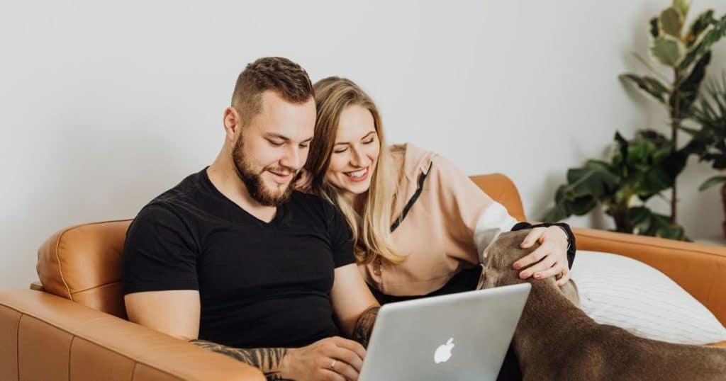 Parent in Houston booking an overnight nanny service on laptop during newborn phase