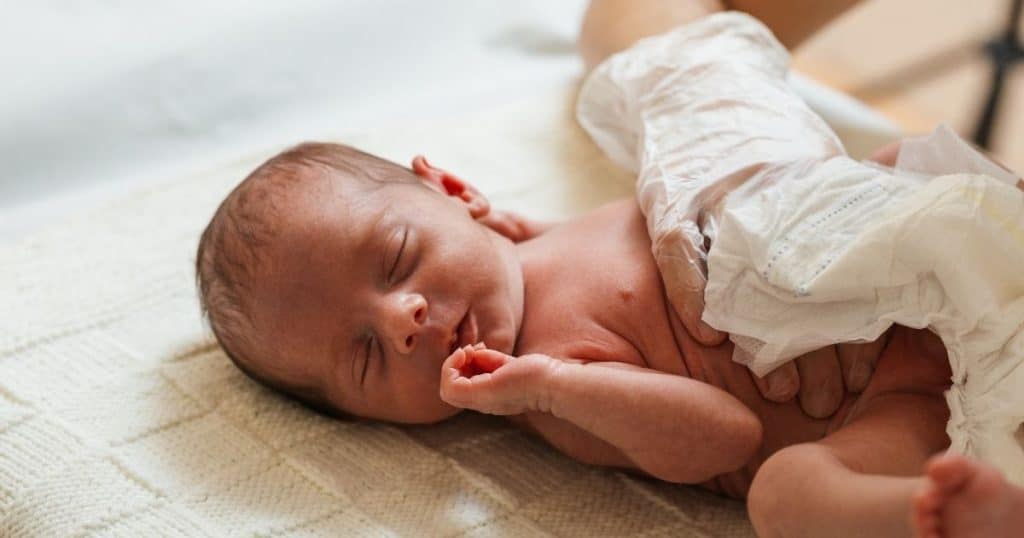 Certified newborn care specialist reviewing infant care training materials and safe sleep guidelines