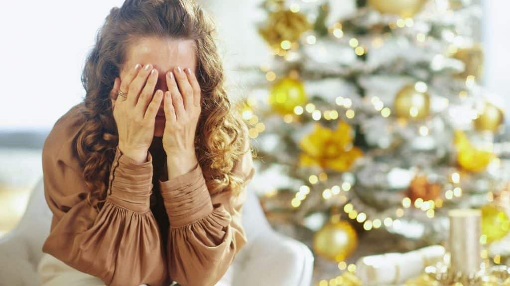 Stressed new parents managing a newborn during winter with holiday clutter and cold weather outside.