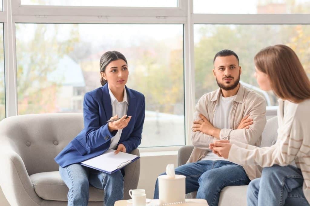 Parents interviewing a newborn care specialist in a comfortable living space