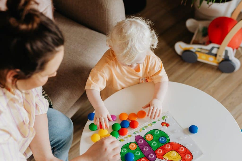 Professional nanny engaging children in structured play in a family home