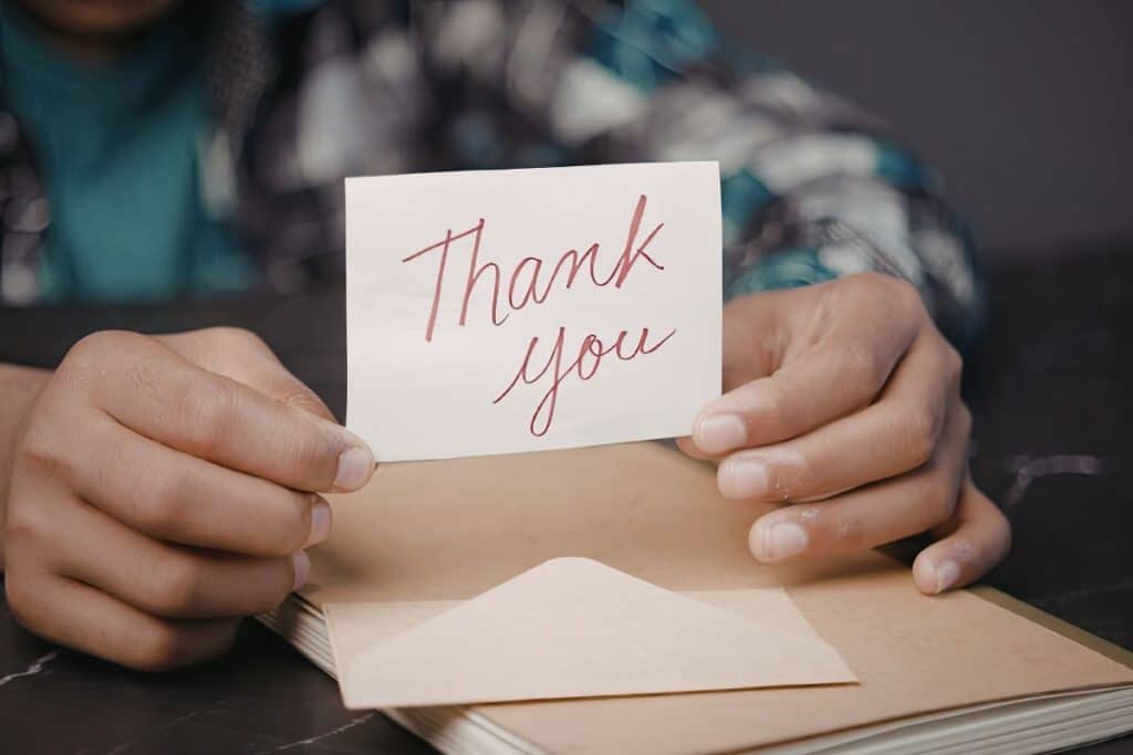 Family expressing gratitude to nanny with a thank-you note or small gift