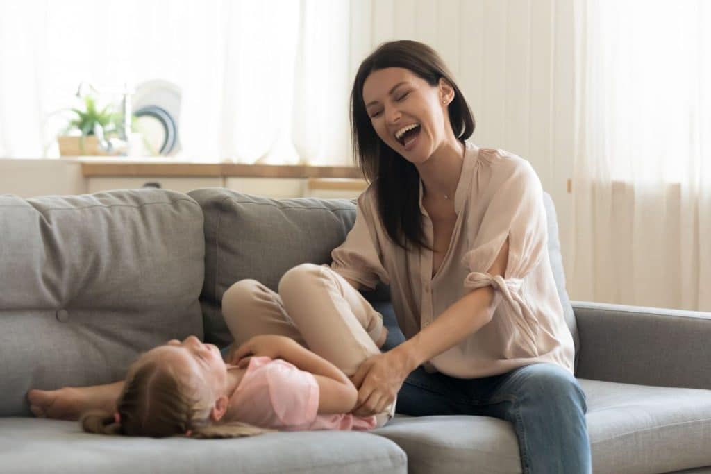 Happy child playing and bonding with nanny in a home environment