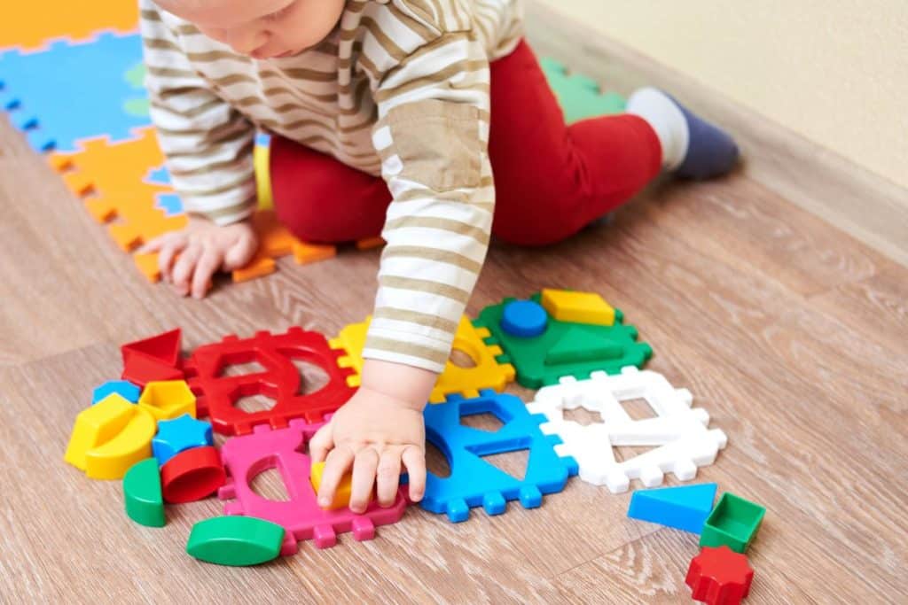 Professional nanny guiding educational play activity for toddler