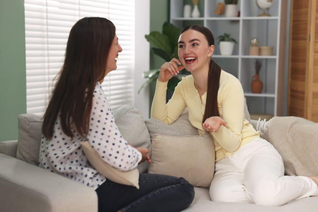 Parent and nanny having a positive weekly check-in conversation in a relaxed home setting