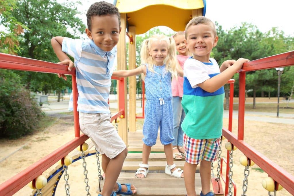 Children socializing at park playgroup organized by nanny
