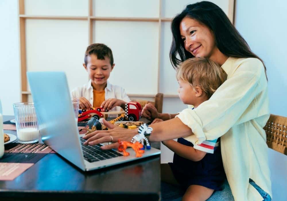 Parent working flexible hours at home with nanny caring for child nearby