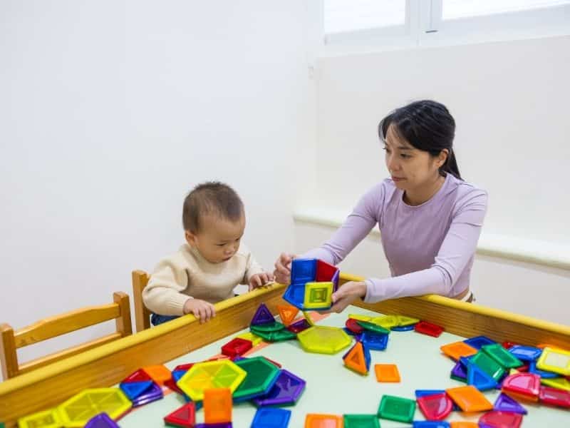 Nanny engaging child in educational play activity