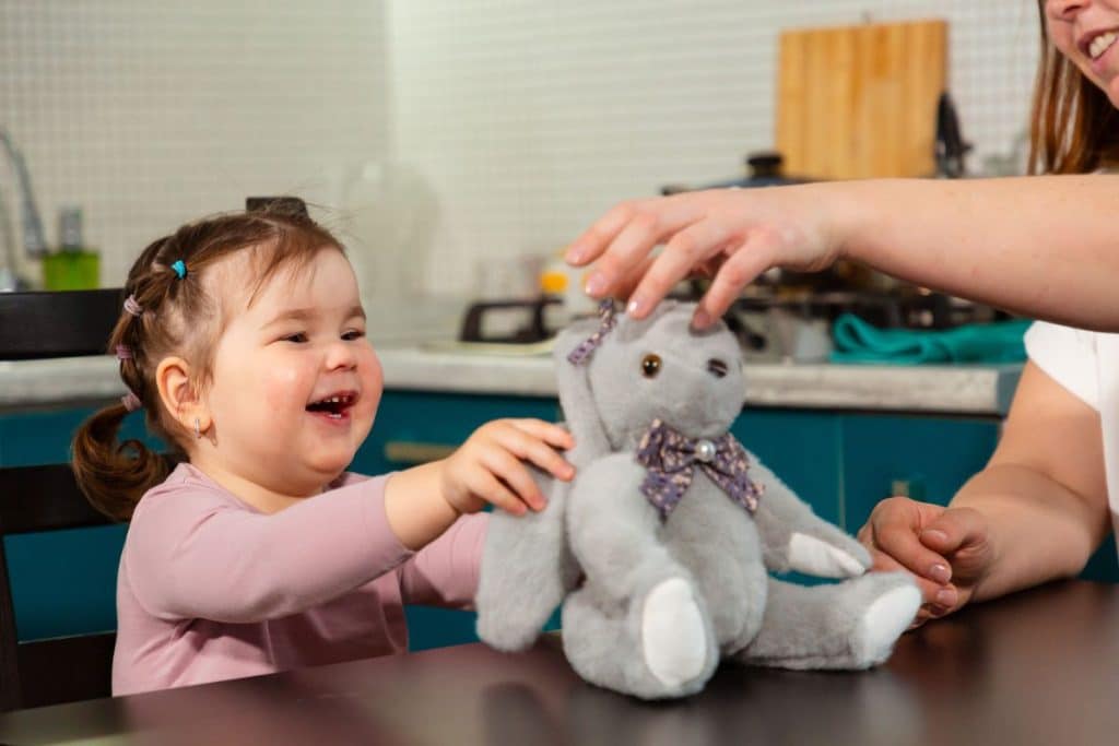 Professional nanny encouraging learning through educational play activities at home