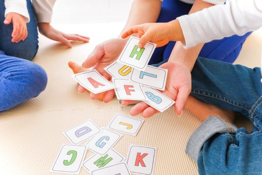 Experienced nanny working with school-age children during a structured summer activity.