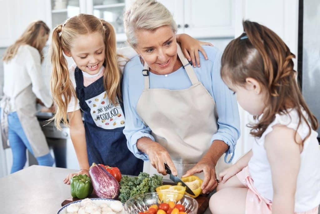 Professional nanny teaching children valuable life skills through hands-on summer activities.