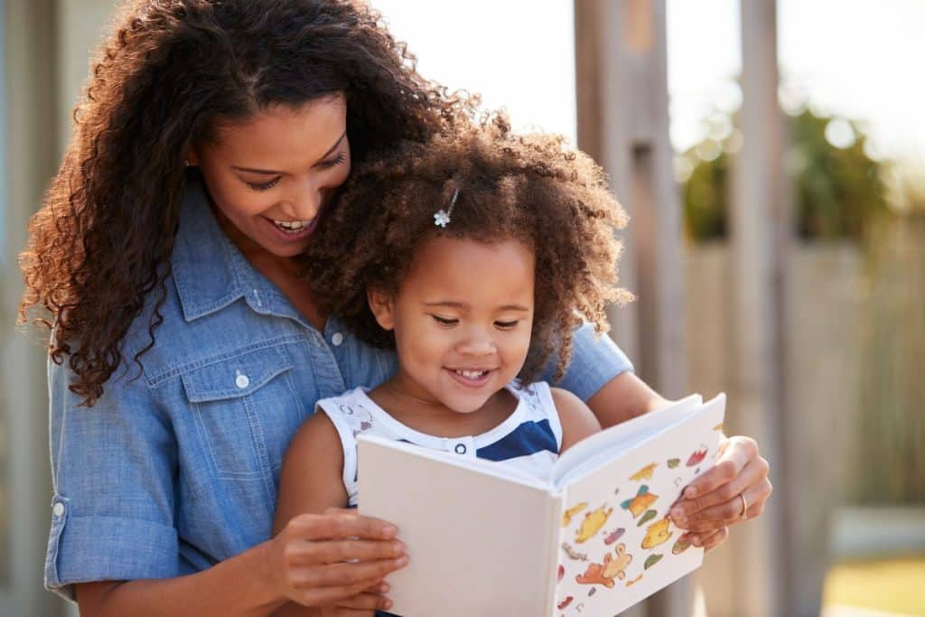 Nanny encouraging children's literacy development through a summer reading program.