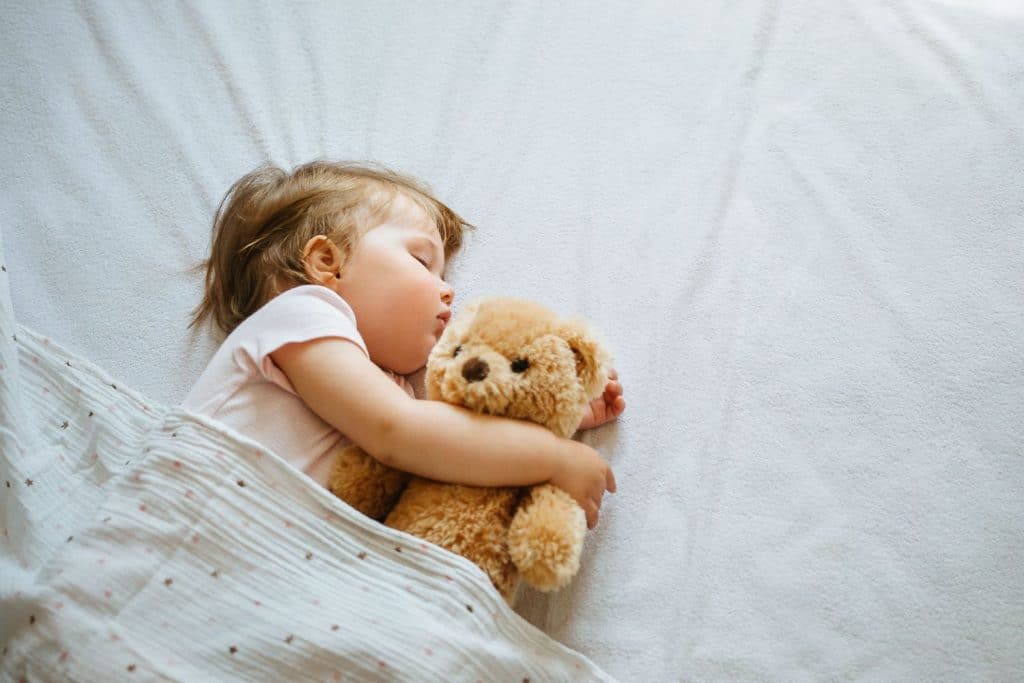 Travel nanny assisting children in a hotel during a family vacation.