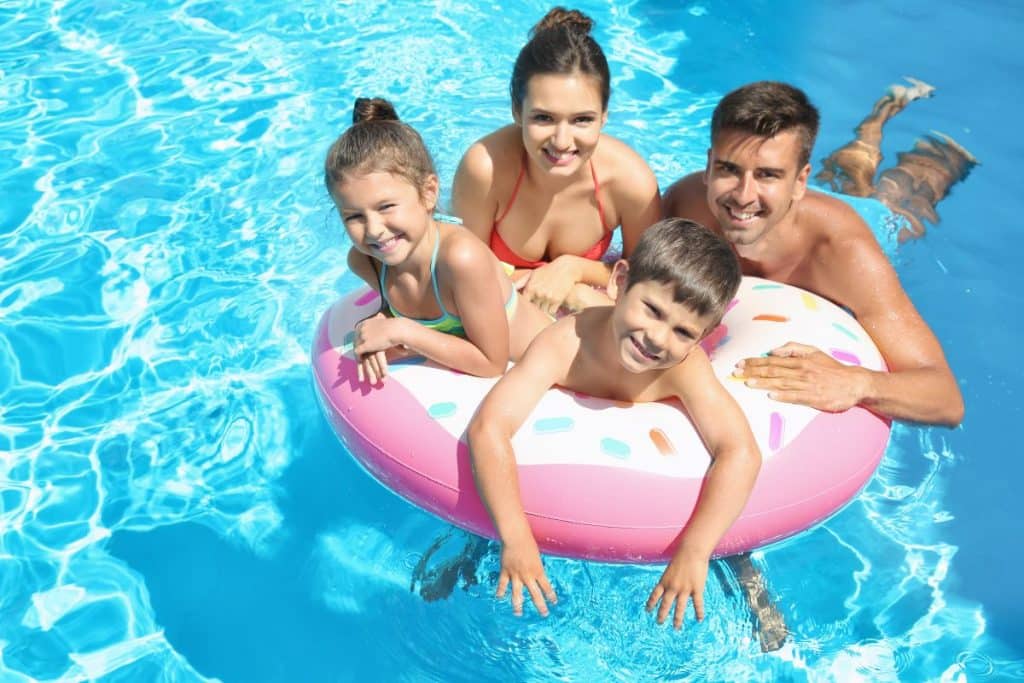 Parents enjoying a summer vacation while a travel nanny provides attentive childcare support.