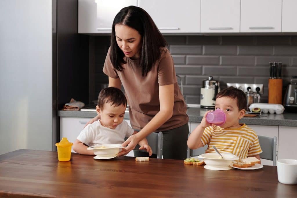 Professional nanny helping children follow a structured morning routine before school.