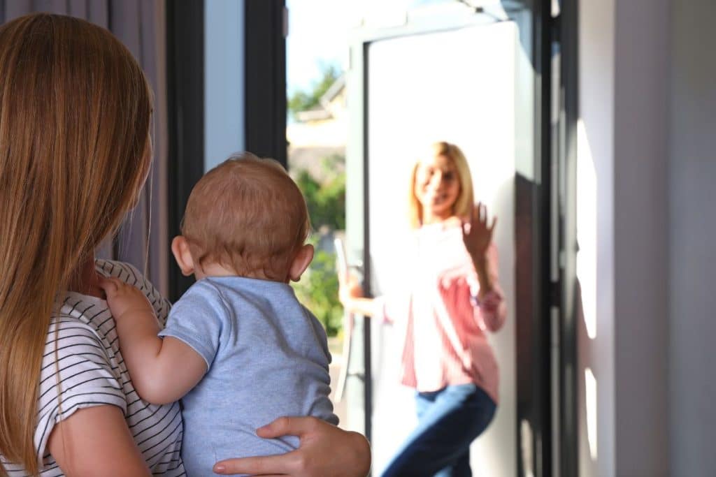 Parent calmly saying goodbye while leaving child in the care of a trusted nanny.