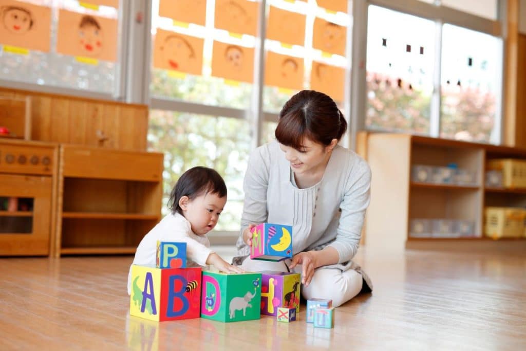 Professional nanny playing educational games with a child to build trust and strengthen their relationship.