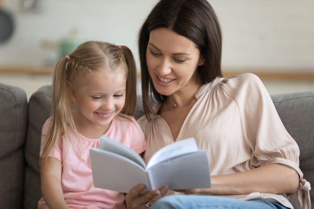 Professional nanny helping a child identify and express different emotions through conversation and learning activities.