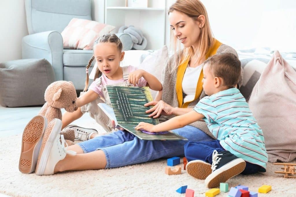 Professional nanny helping siblings resolve a disagreement over a toy