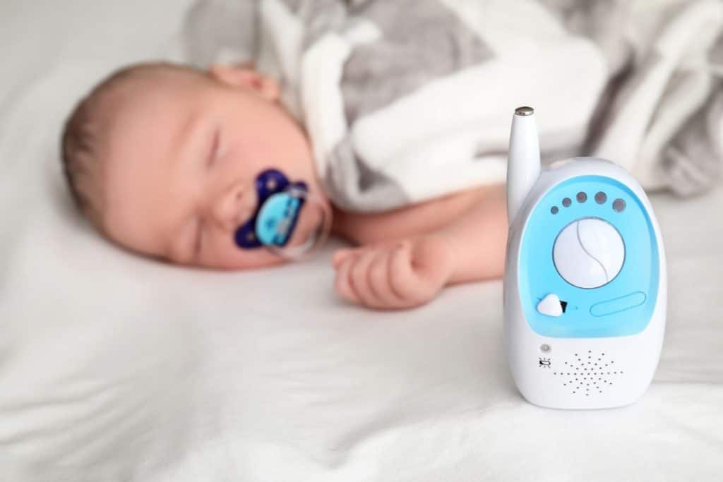 Nanny practicing safe infant care and monitoring a young child