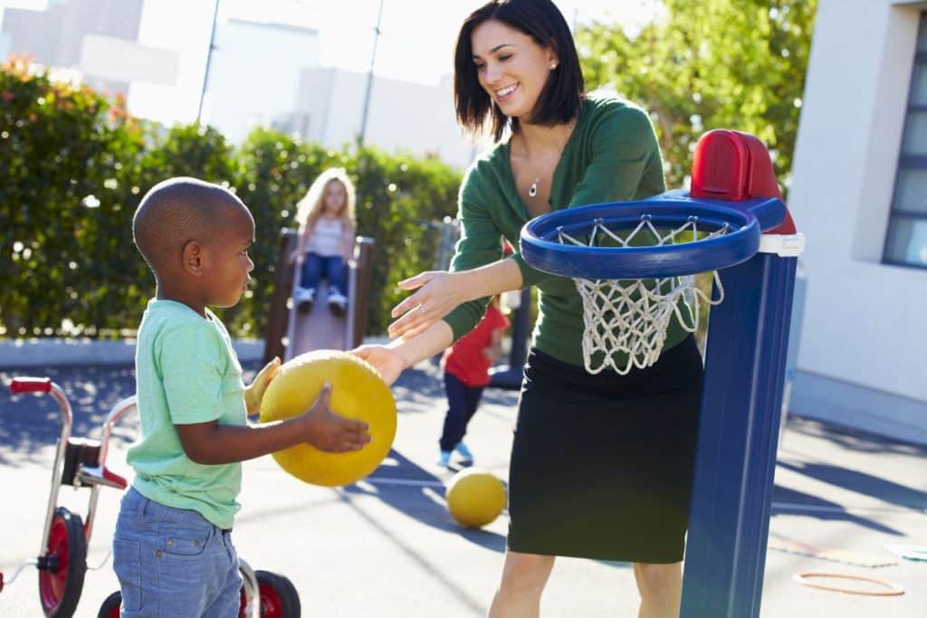 Professional nanny supervising children during a safe outdoor activity