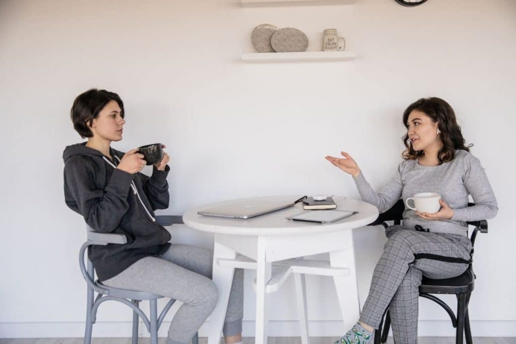 Parent and professional nanny discussing a child's behavior and childcare approach