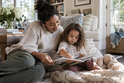 Professional nanny and child reading together in a calm family home.